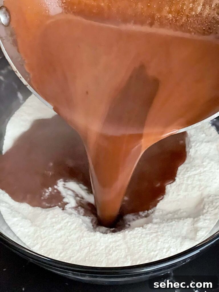 Boiled chocolate mixture being poured into the dry ingredients for buttermilk brownies.