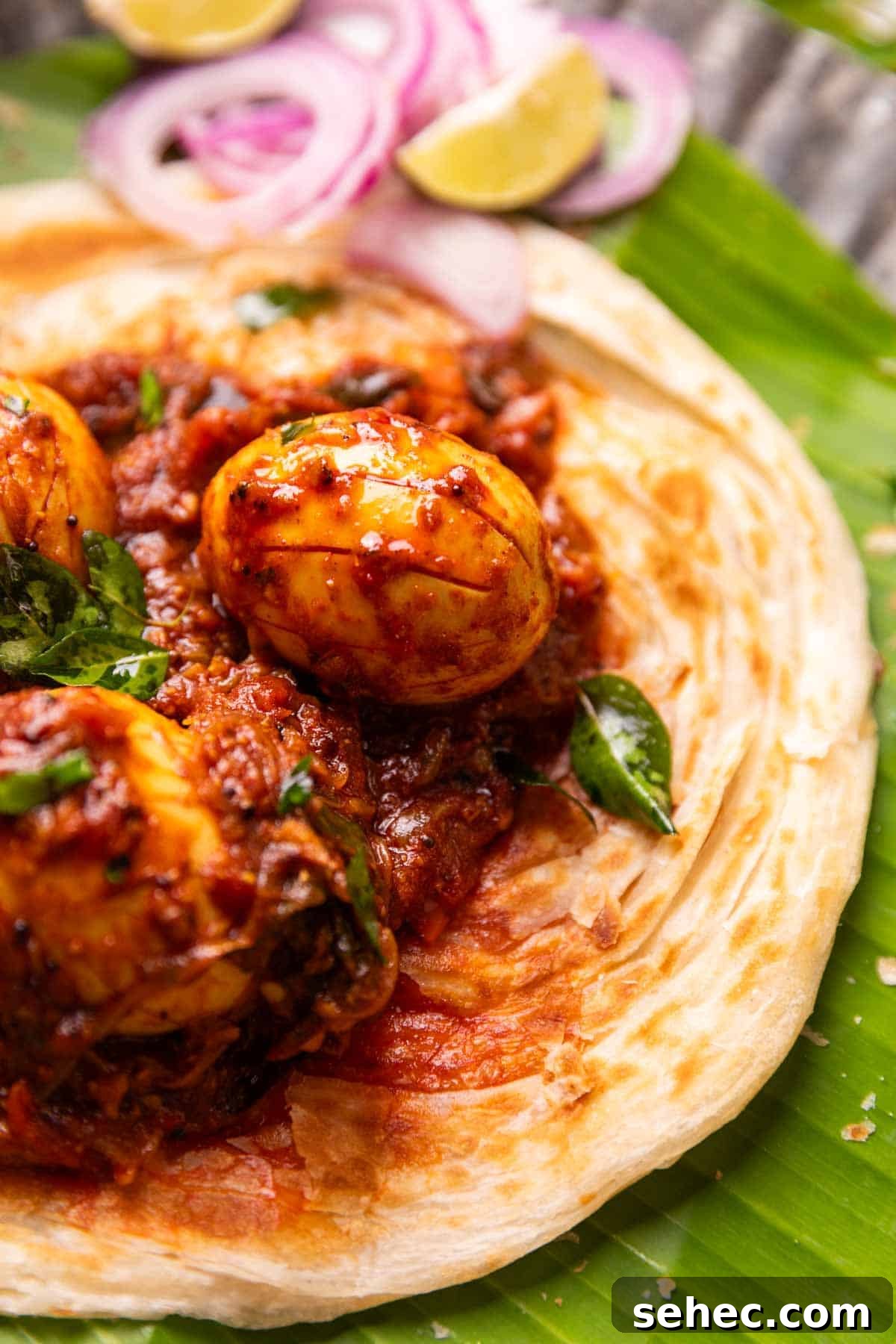 Kerala Egg Roast Mutta Roast Recipe 3 close up image of Kerala egg roast served on Malabar Parotta