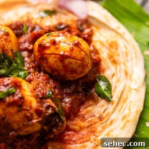 Kerala Egg Roast Mutta Roast Recipe 4 close up image of Kerala egg roast served on Malabar Parotta