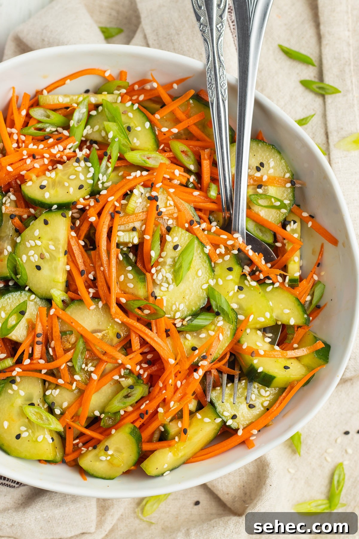 Crunchy Cucumber Carrot Salad Recipe 2 This is a picture of cucumber and carrot salad in a white bowl.
