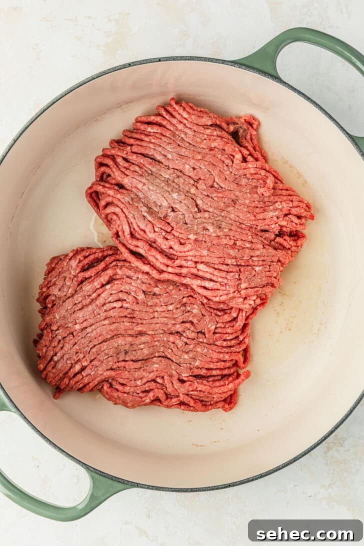 Chili Charcuterie Board with Homemade Chili Recipe 4 A green Dutch oven with raw ground beef.