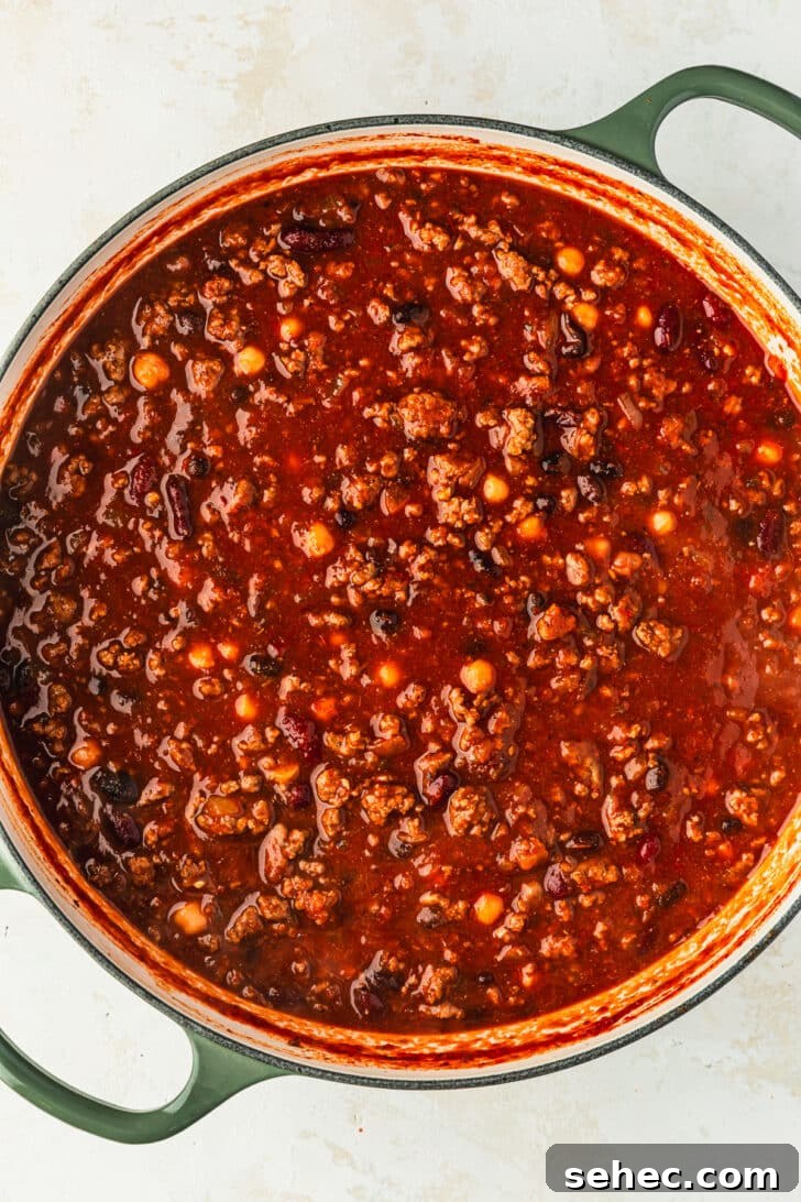 Chili Charcuterie Board with Homemade Chili Recipe 9 A green Dutch oven of chili for a chili toppings charcuterie board.