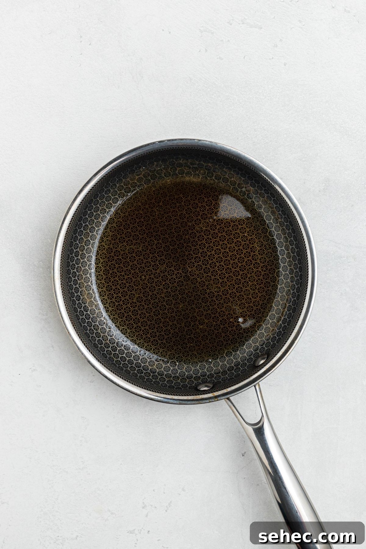 Juicy Smoked Pork Tenderloin Recipe 7 Small saucepan with sauce in it, before being brushed on pork tenderloin.