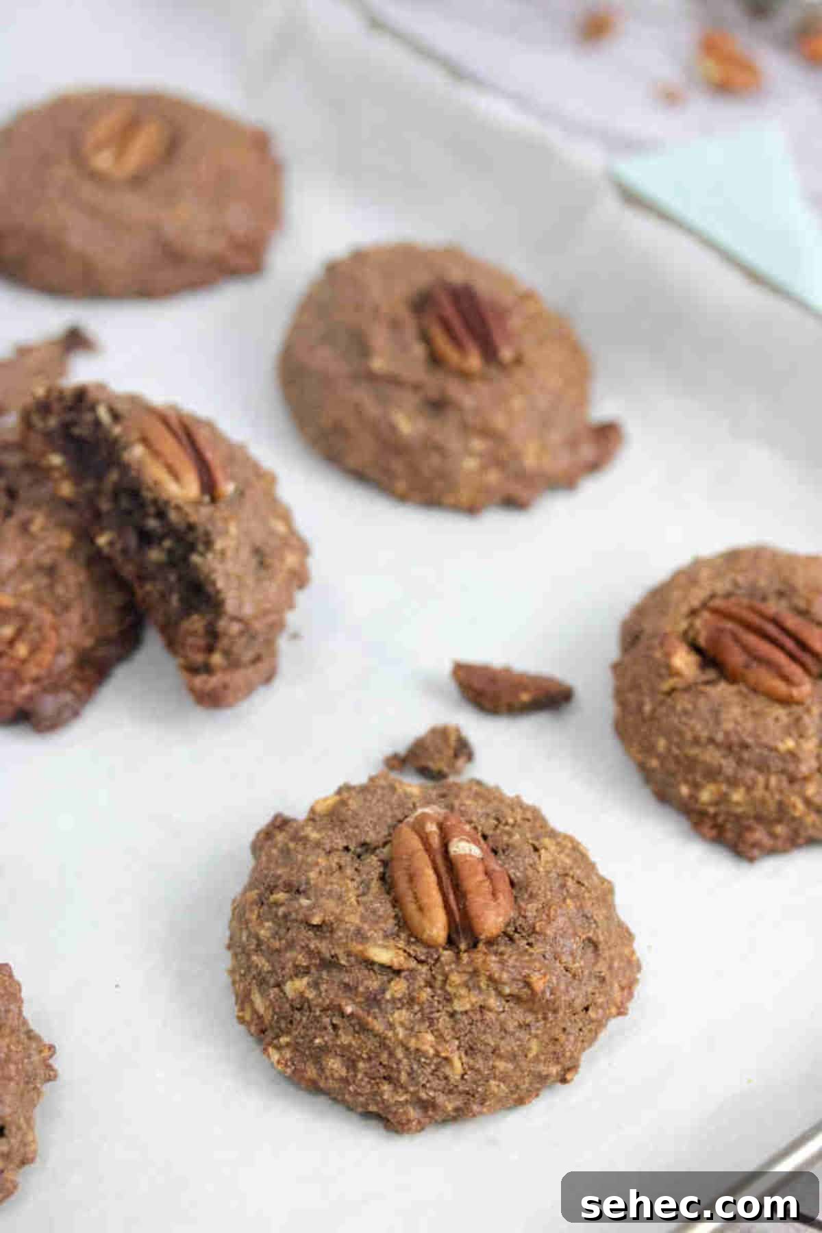 High Protein Cookies for Pregnancy 2 Chocolate pregnancy cookies with pecans on top on a baking sheet with parchment paper.