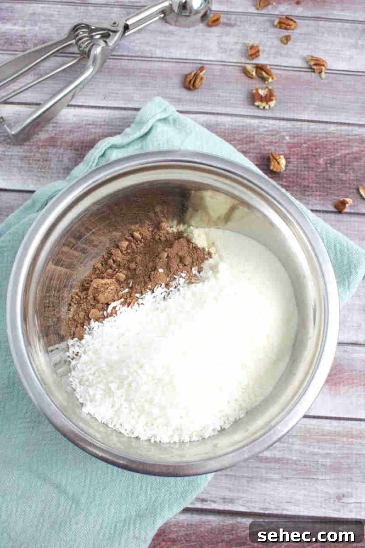High Protein Cookies for Pregnancy 4 Steel bowl with cacao powder, coconut and almond flour on a blue linen and pecans around it.