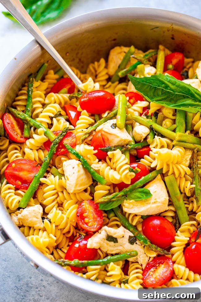 Chicken Asparagus Pasta with Tomatoes 3 Chicken Asparagus Pasta in a pot with a spoon.