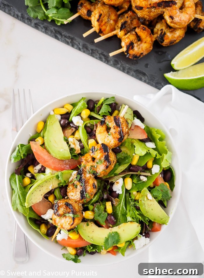 Southwestern Grilled Shrimp Salad with Avocado 2 Southwestern Grilled Shrimp Salad served in bowl with extra shrimp and lime on the side.