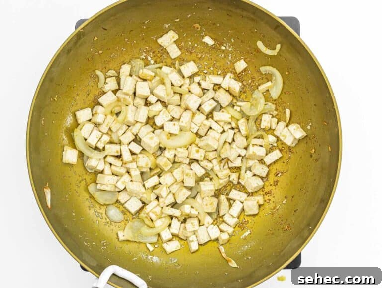 Yaki Udon Stir Fried Noodles 29 tofu cubes and fried onion in a wok