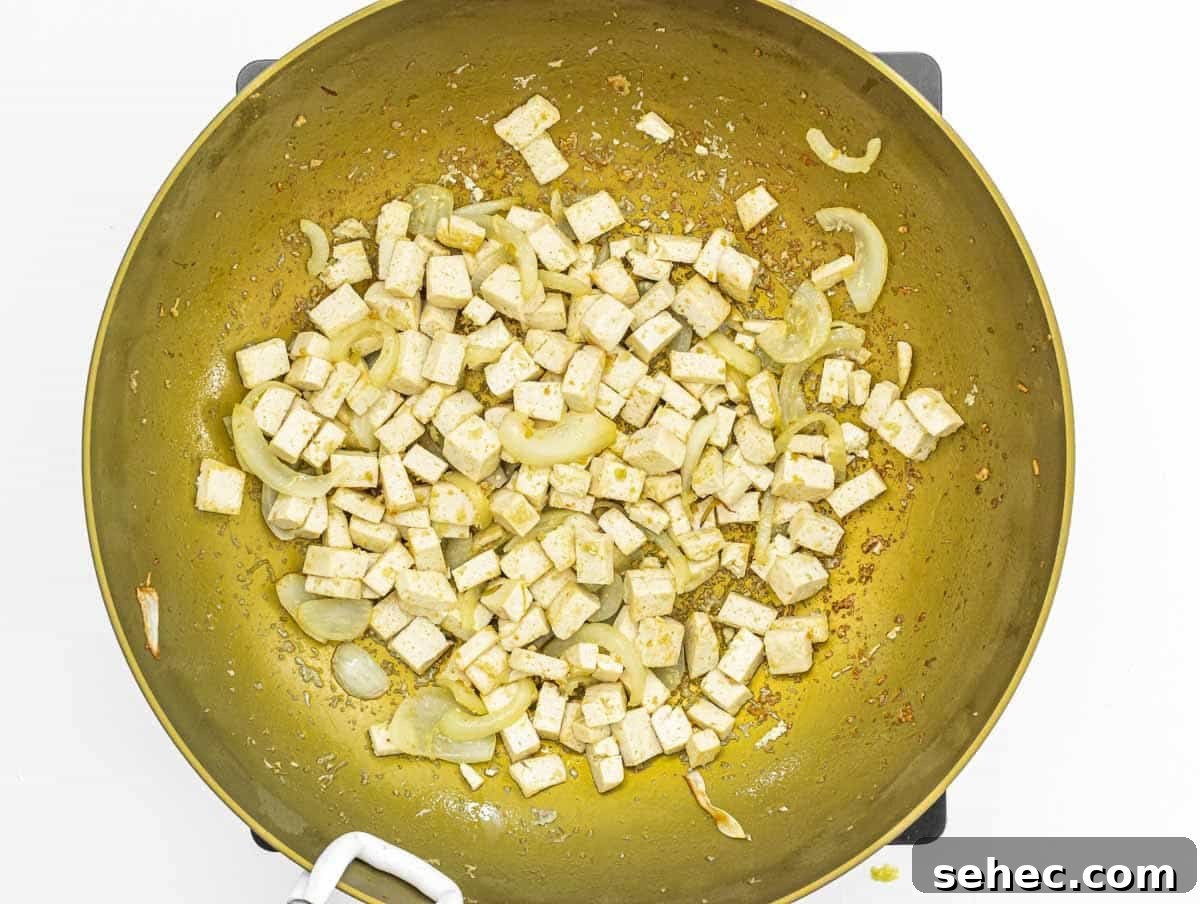 Yaki Udon Stir Fried Noodles 10 tofu cubes and fried onion in a wok