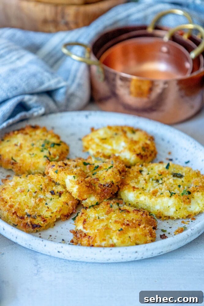 Crispy Baked Goat Cheese Balls Recipe 13 golden baked breaded goat cheese balls topped with herbs on a white speckled plate