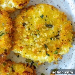 Crispy Baked Goat Cheese Balls Recipe 24 golden baked panko covered goat cheese balls on a white speckled plate topped with dried herbs