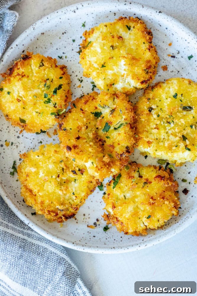 Crispy Baked Goat Cheese Balls Recipe 4 golden baked breaded goat cheese balls topped with herbs on a white speckled plate