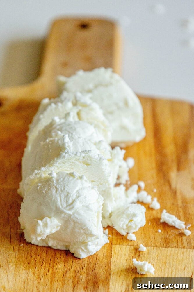 Crispy Baked Goat Cheese Balls Recipe 6 sliced goat cheese on a wooden cutting board