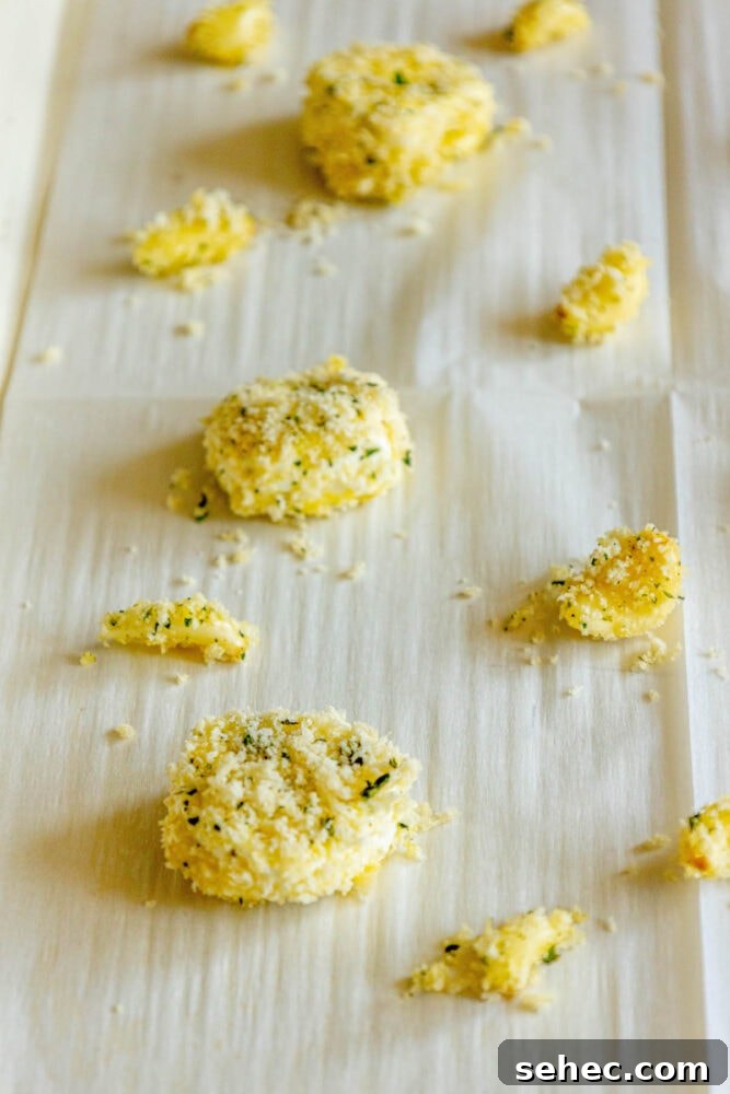 Crispy Baked Goat Cheese Balls Recipe 10 goat cheese balls and garlic cloves rolled in breadcrumbs on parchment paper