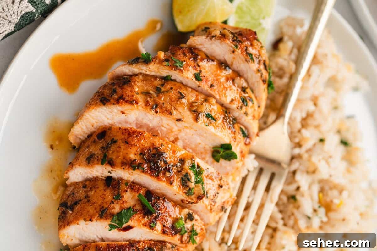Garlic Lime Chicken Recipe with Juicy Citrus Flavor 7 Slices of garlic lime chicken on a plate with rice and a fork.