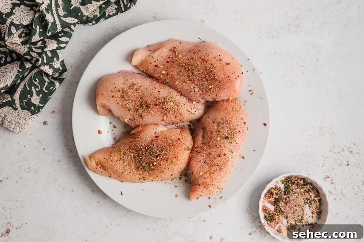 Garlic Lime Chicken Recipe with Juicy Citrus Flavor 4 Seasoned chicken breasts on a white plate.