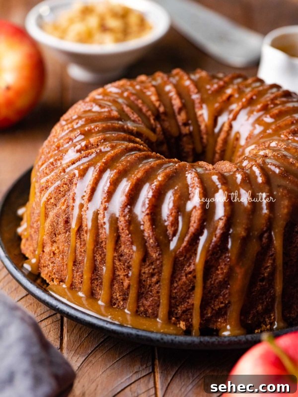 Moist Marble Bundt Cake Recipe 16 Homemade apple bundt cake with brown sugar glaze surrounded by an apple and chef's knife on dark wood background.