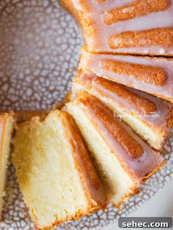 Moist Marble Bundt Cake Recipe 19 Sliced lemon cream cheese pound cake with a lemon glaze on a ceramic cake stand.