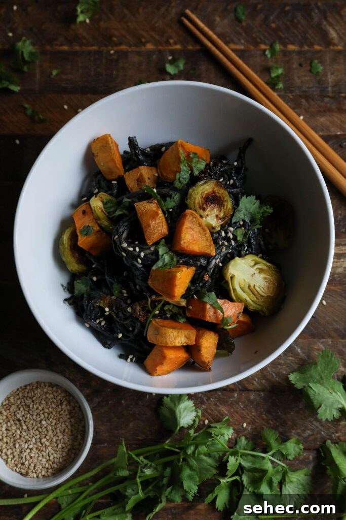 Black Sesame Noodle Bowl served in bowl topped with cilantro and sesame seeds