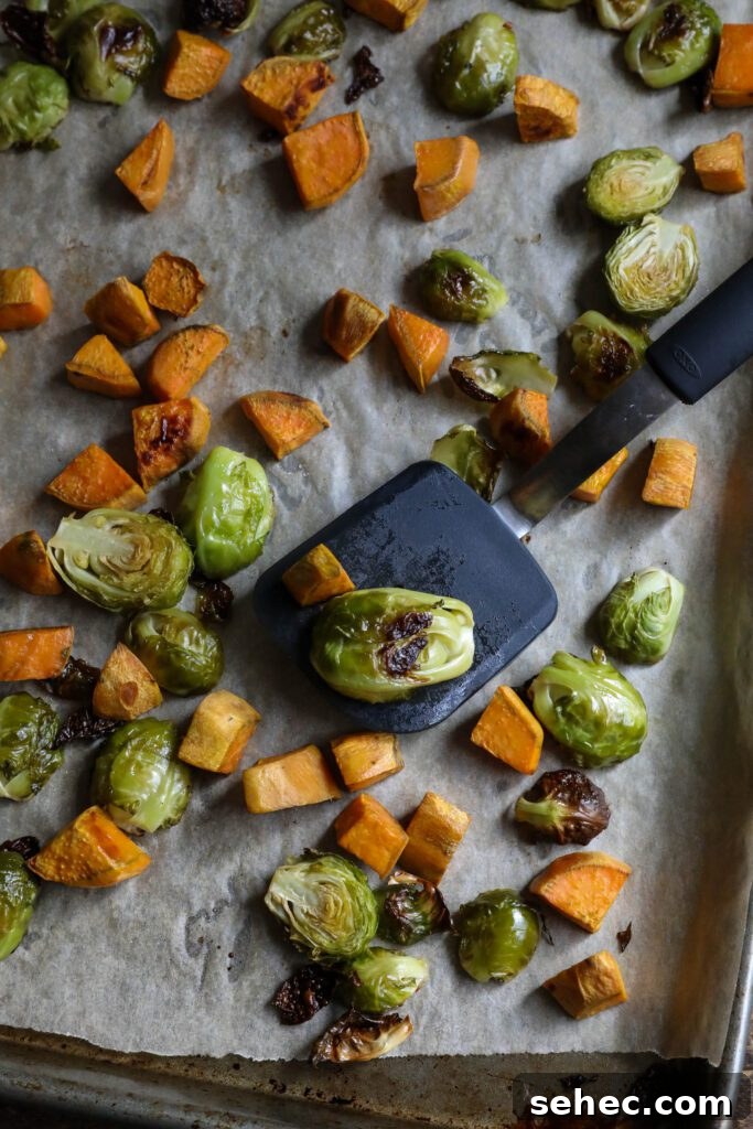 Black Sesame Noodle Bowl with Crunchy Vegetables 8 roasted brussels sprouts and sweet potato on parchment lined baking sheet