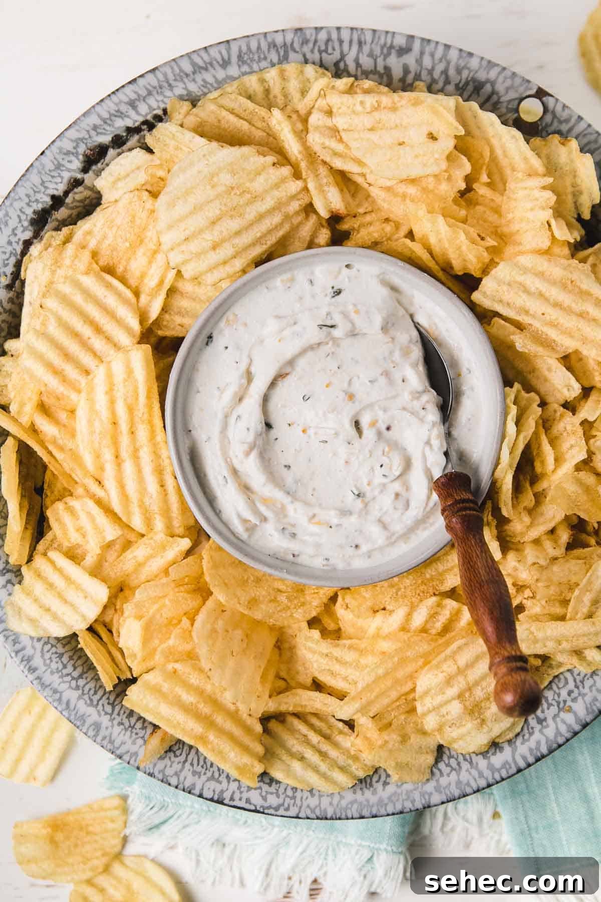 Gluten Free French Onion Chip Dip Recipe 2 Gluten-free French onion chip dip in old enamelware bowl surrounded by wavy potato chips.