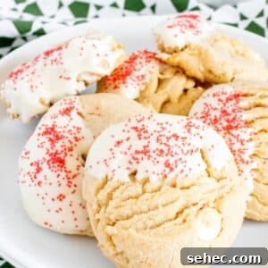 White Chocolate Peanut Butter Cookies Recipe 12 Peanut butter white chocolate chip cookies decorated with red sprinkles on a white plate.