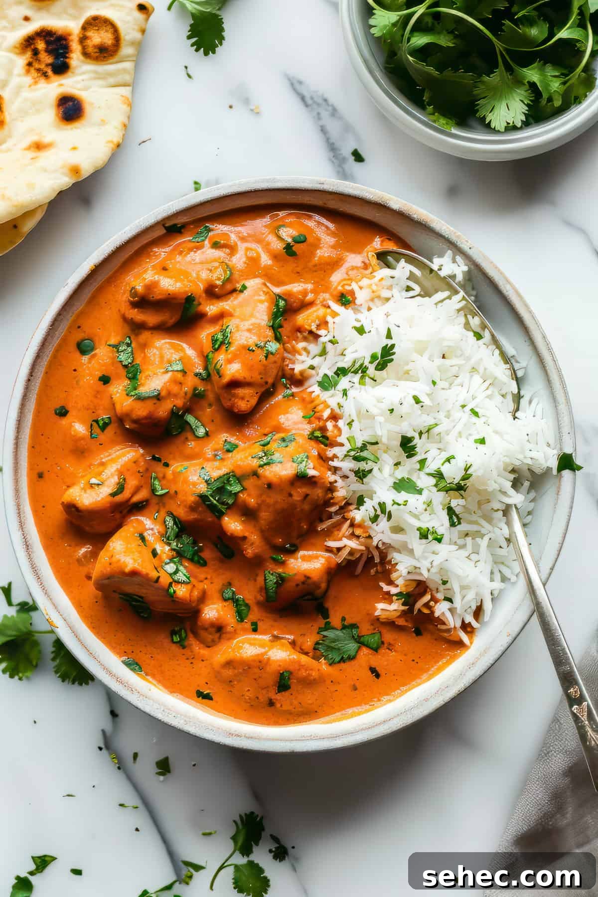 Indian Butter Chicken Recipe with Creamy Tomato Sauce 2 Indian butter chicken with rice in a white bowl.