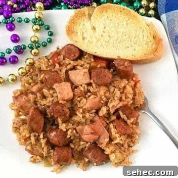 Cajun Chicken and Sausage Jambalaya Recipe 6 chicken and sausage jambalaya on white plate with mardi gras beads on the side