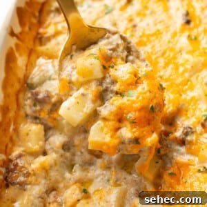 Cheesy Ground Beef Potato Casserole 8 closeup of ground beef and potato casserole with a serving spoon