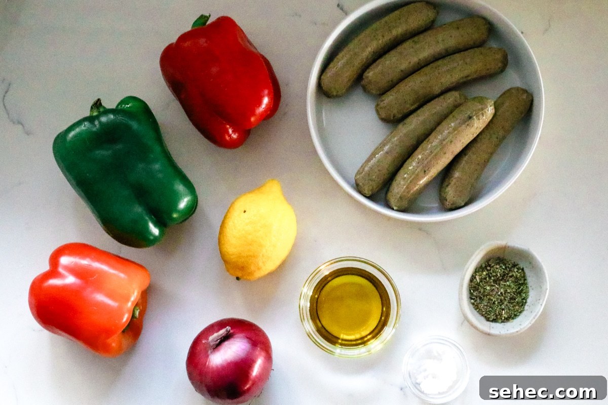 Oven Baked Sausage and Peppers Recipe 4 Ingredients for sausage and peppers on a white table.