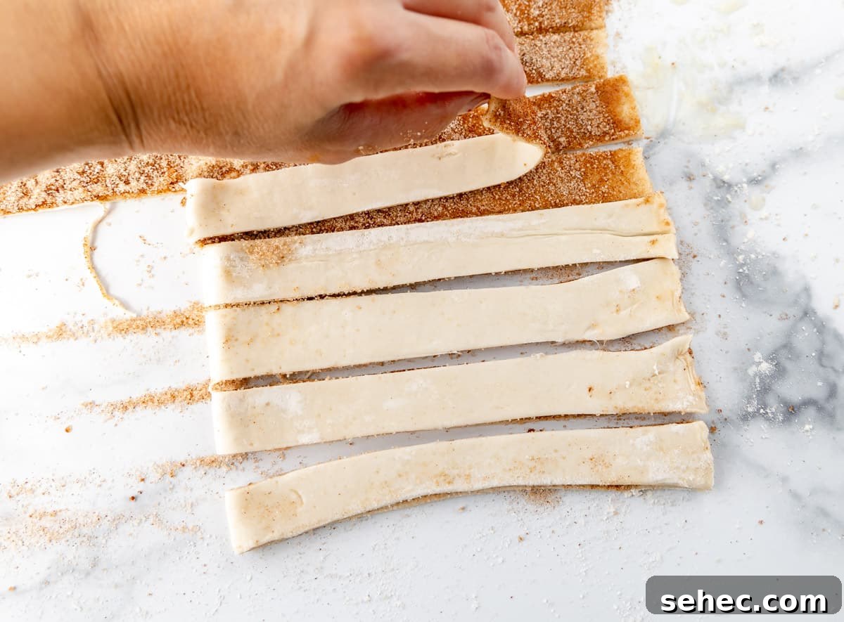 Cinnamon Sugar Puff Pastry Twists 6 Folding the puff pastry strips in half. Pressing the cinnamon sides together to adhere.