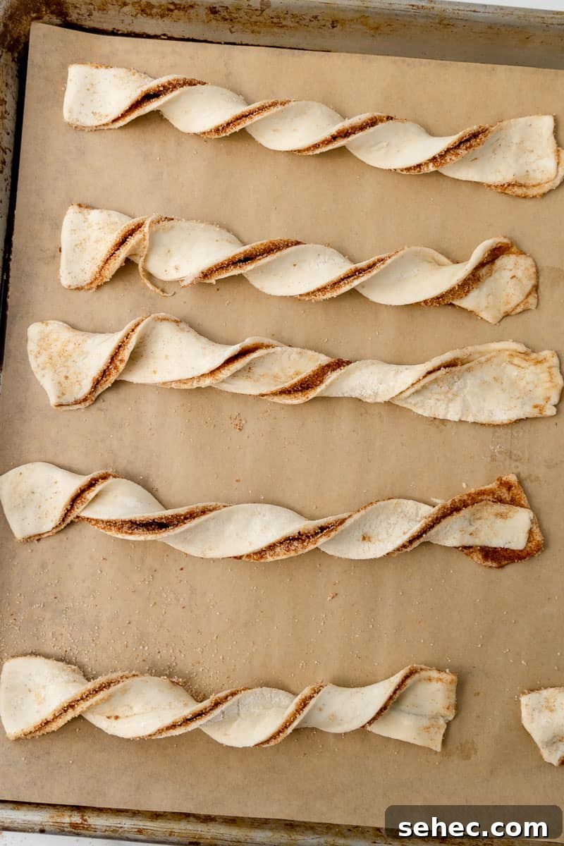 Cinnamon Sugar Puff Pastry Twists 8 Pastry twists lined up on a sheet pan.
