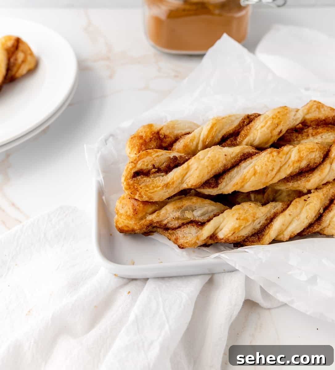 Cinnamon Sugar Puff Pastry Twists 10 A plate of puff pastry twists and a jar of ground cinnamon