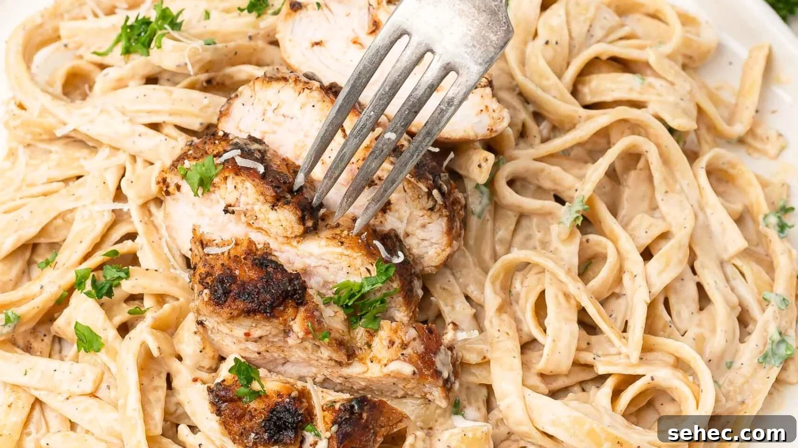 Blackened chicken served over pasta in Alfredo sauce.