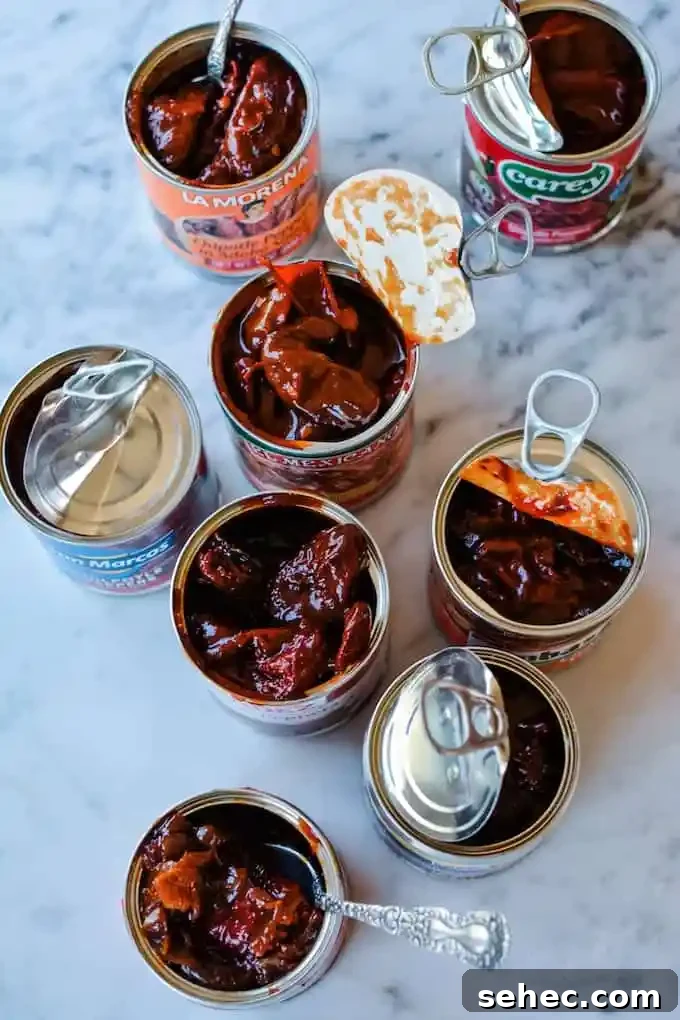 Over 35 Recipes Using Canned Chipotle Peppers in Adobo 3 Several cans of chipotle peppers in adobo sauce that are open and sitting on a marble table.