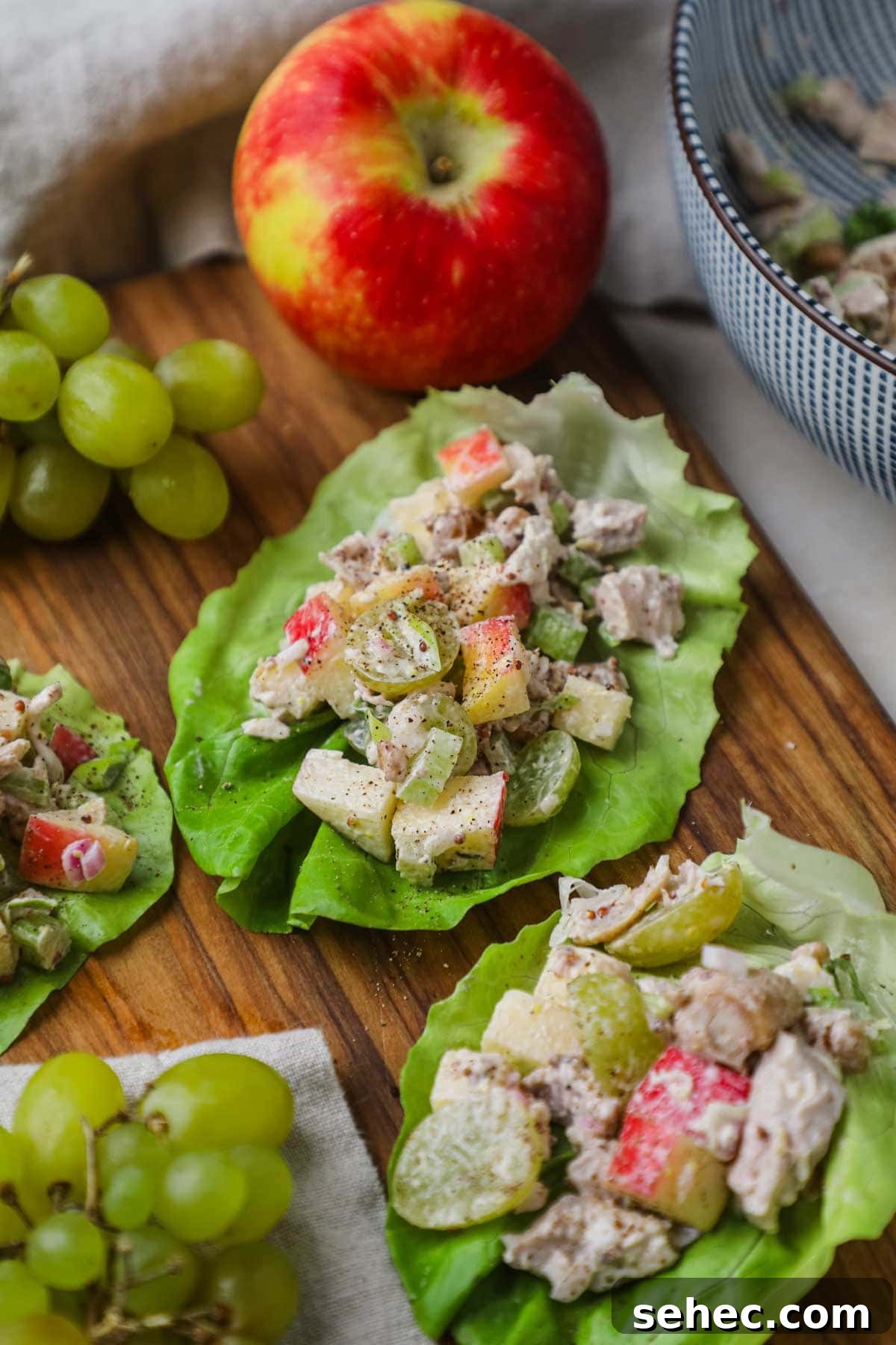 Healthy chicken salad lettuce wrap cups served on a wooden board for a delicious, satisfying lunch.