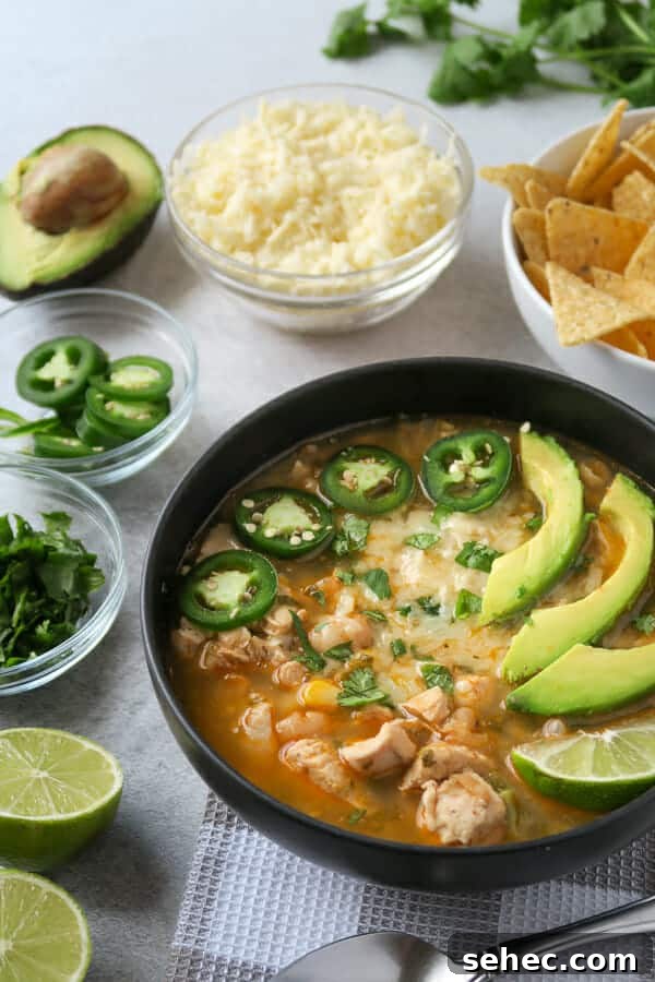 Dairy Free Instant Pot White Chicken Chili 2 instant pot white chicken chili (dairy-free) shown with toppings: jalapeño, avocado, cilantro, Monterey jack cheese, and limes