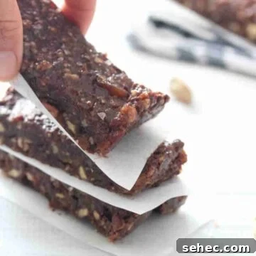 Dairy Free Chocolate Mint Protein Bars Recipe 13 Fingers placing a mint chocolate protein bar onto a stack.
