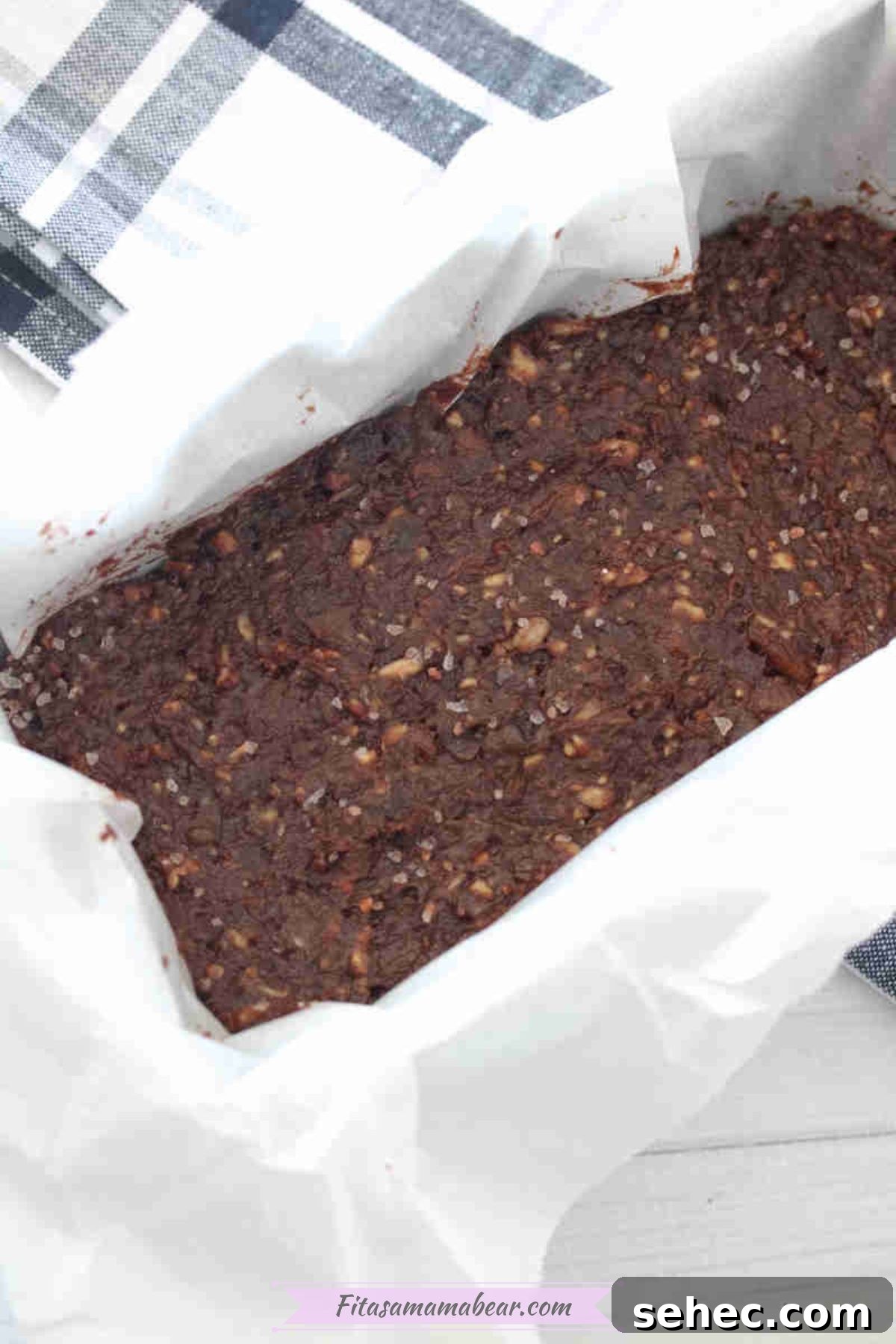 Dairy Free Chocolate Mint Protein Bars Recipe 6 Chocolate date protein bars in a loaf pan lined with parchment paper.