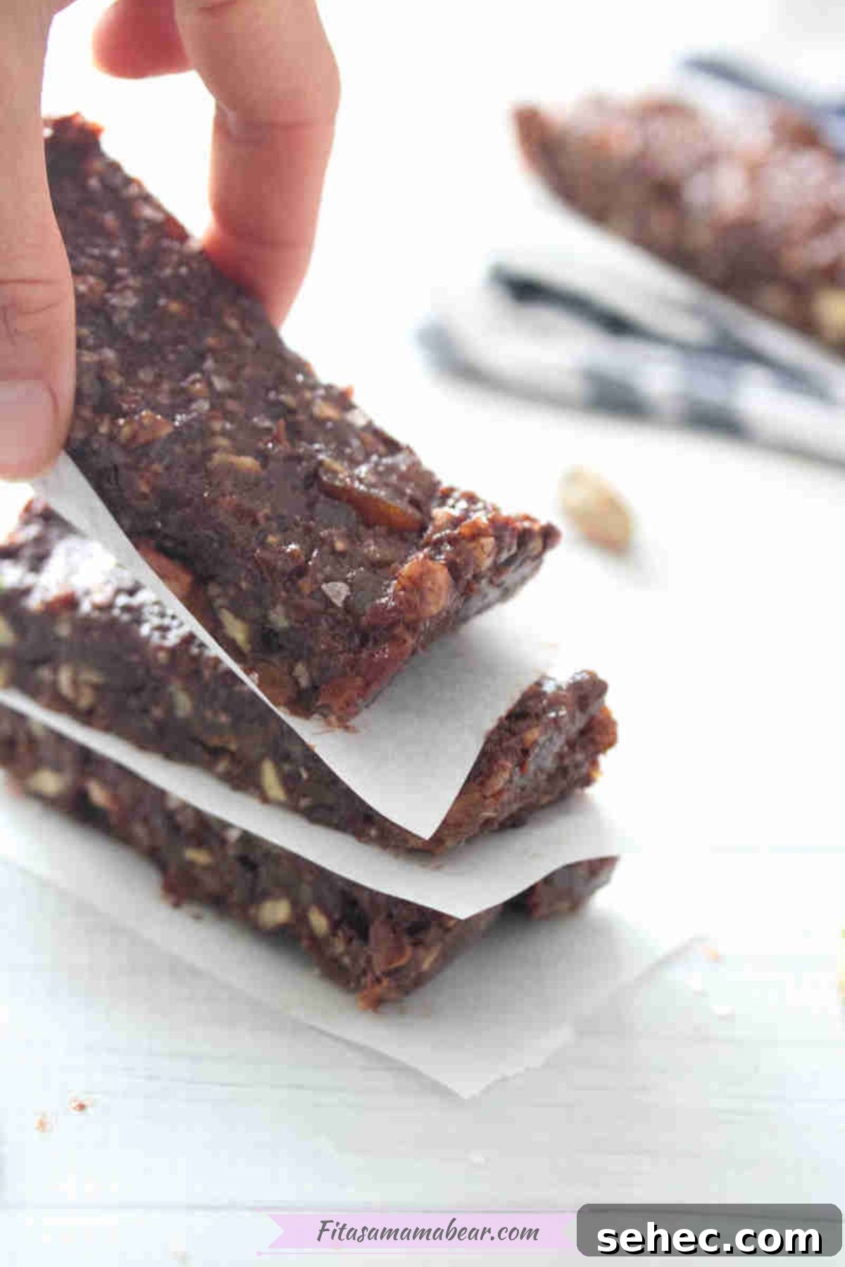 Dairy Free Chocolate Mint Protein Bars Recipe 8 Fingers placing a mint chocolate protein bar onto a stack.