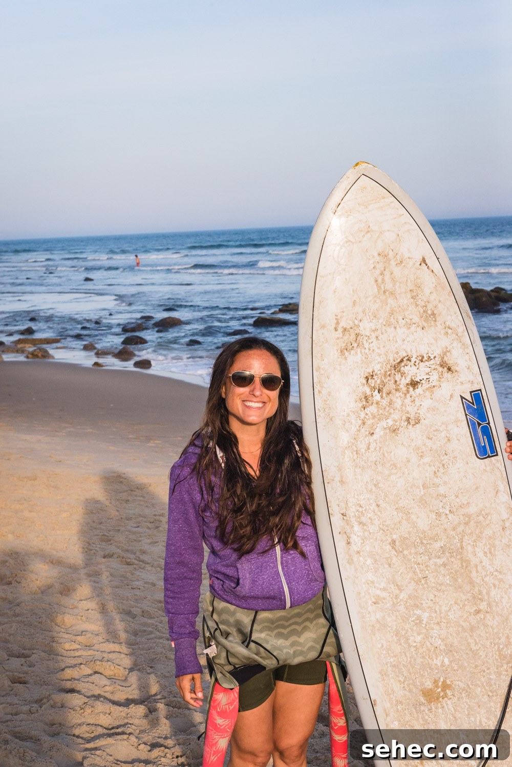 Ditch Plains Surf Guide Waves Tides and Local Tips 2 Chef Daniela Gerson holding her surfboard in Ditch Plains, NY.