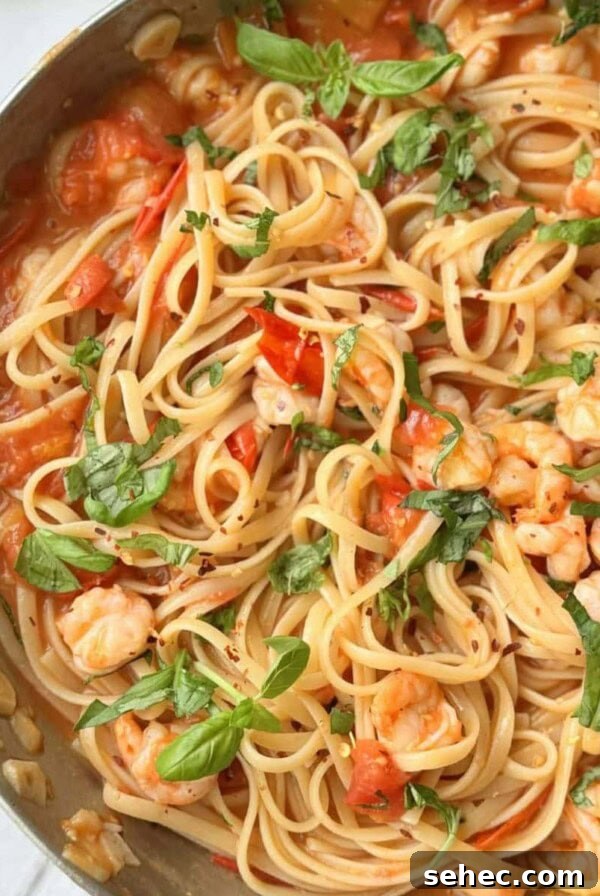 Stanley Tucci's Pasta Fagioli Recipe 11 prawn tomato linguine in a silver pan.