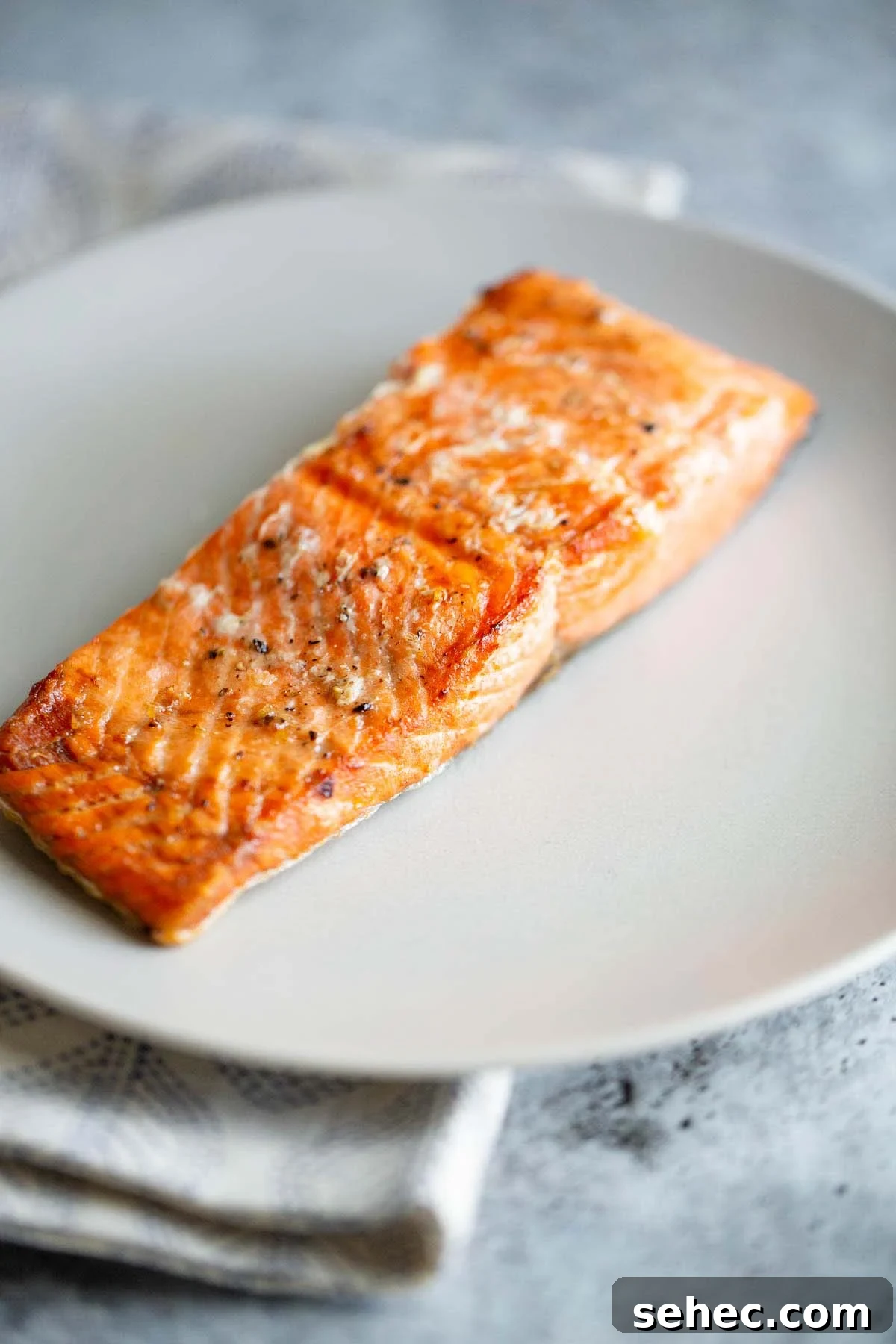 Crispy Skin Air Fryer Salmon Recipe 3 Air fried salmon on a white plate.