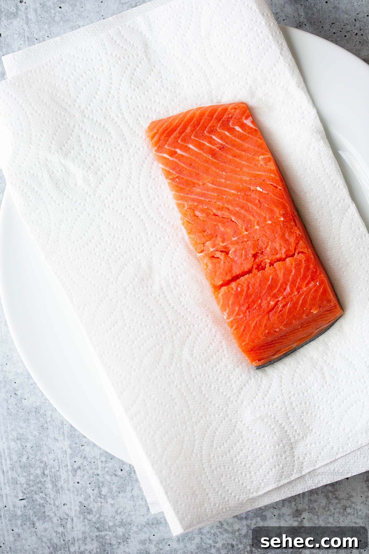 Crispy Skin Air Fryer Salmon Recipe 5 Raw salmon on a white plate.