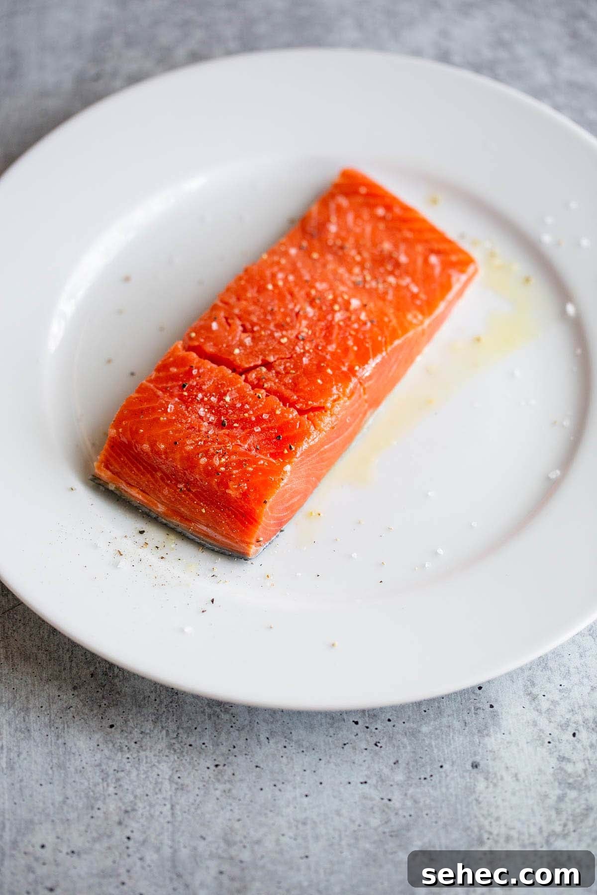 Crispy Skin Air Fryer Salmon Recipe 6 Raw salmon on a white plate.