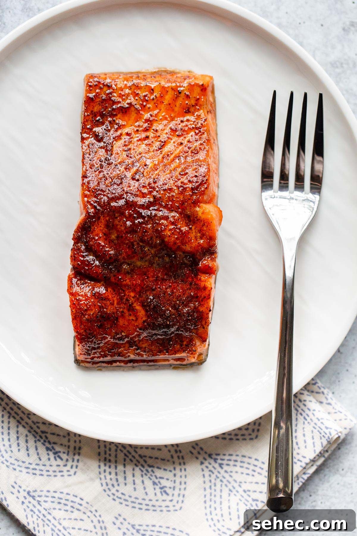 Crispy Skin Air Fryer Salmon Recipe 9 Cooked salmon on a white plate with a fork.