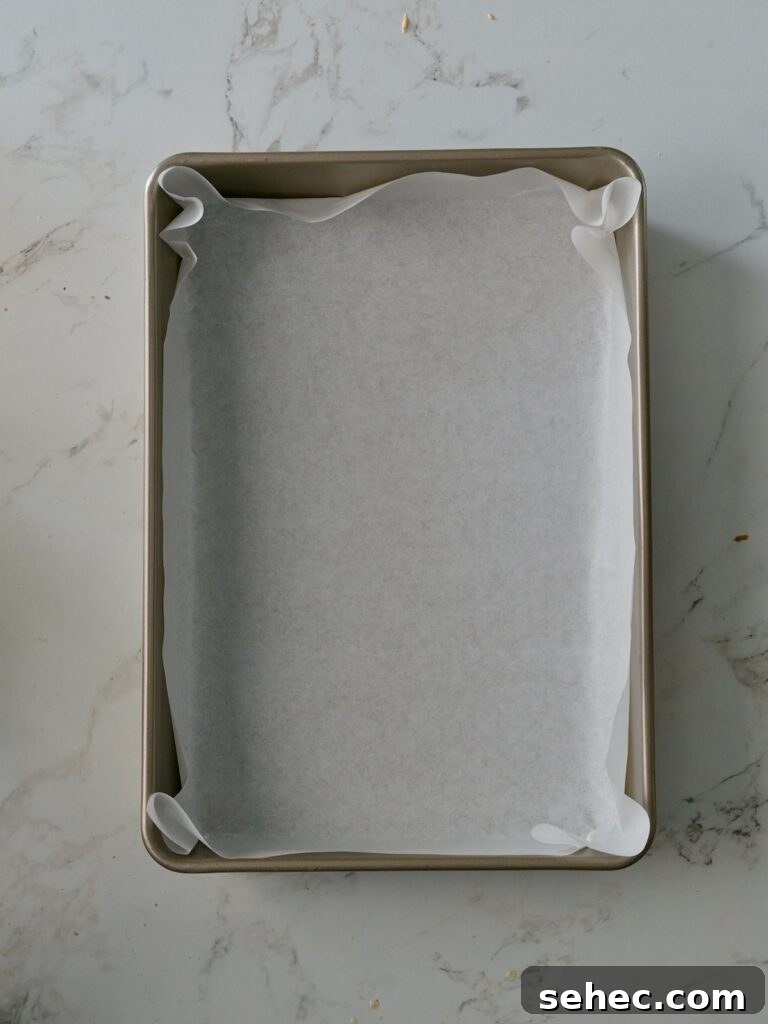 Moist Applesauce Crumb Cake with Cinnamon Streusel 10 A rectangular cake pan lined neatly with parchment paper.