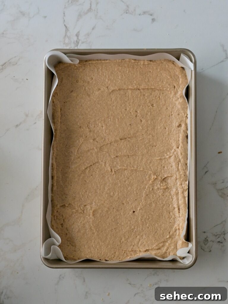 Moist Applesauce Crumb Cake with Cinnamon Streusel 13 Applesauce cake batter spread evenly into a parchment-lined cake pan.