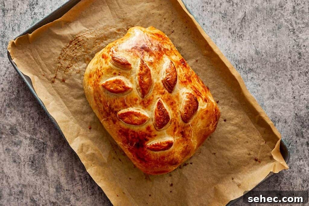 Truffle Beef Wellington Recipe with Red Wine Sauce 15 cooked beef Wellington resting on a pan