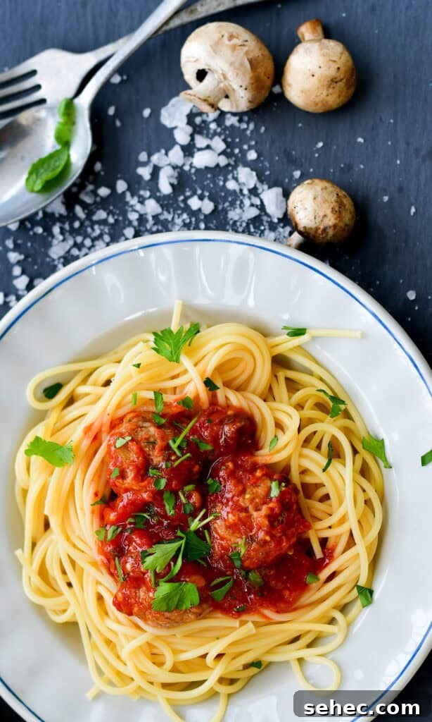 white plate of spaghetti and sauce.